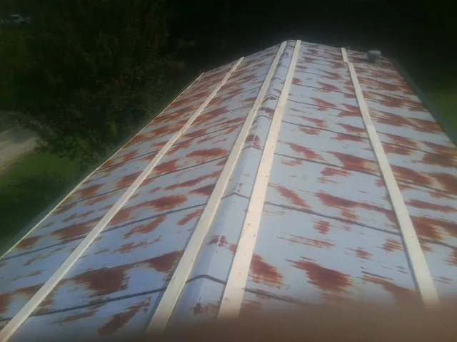 Rusted metal roof panels with new wood purlins before replacement — Storm Damage Roof Repair in Warner Robins by Roofing Brothers
