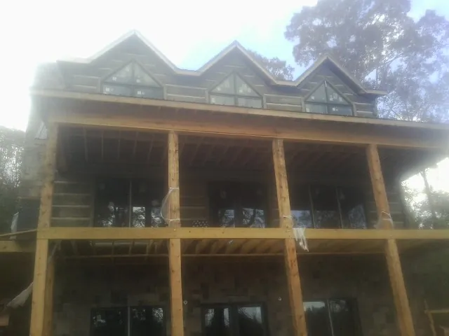 Dormers and porch framing on a large log home under construction — Roof Coating work by our crew in Warner Robins