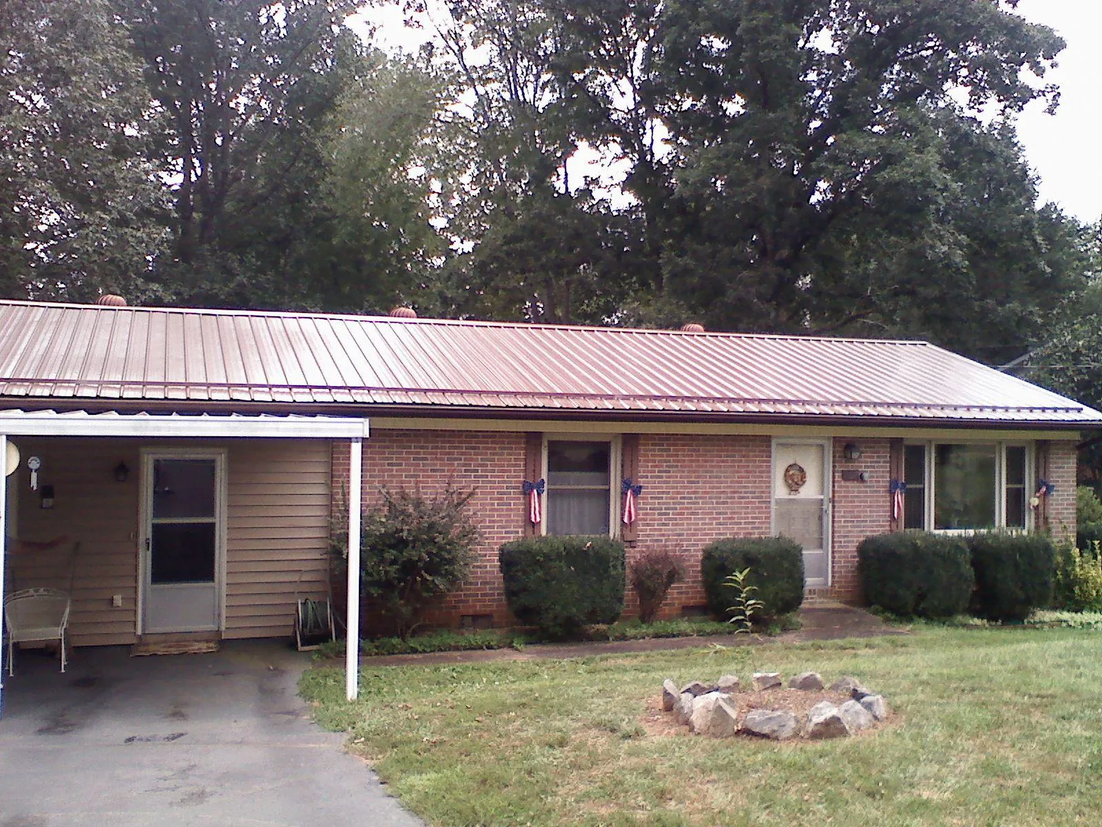 Bronze metal roof and carport on a brick ranch home — Roof Repair work by our crew in Warner Robins