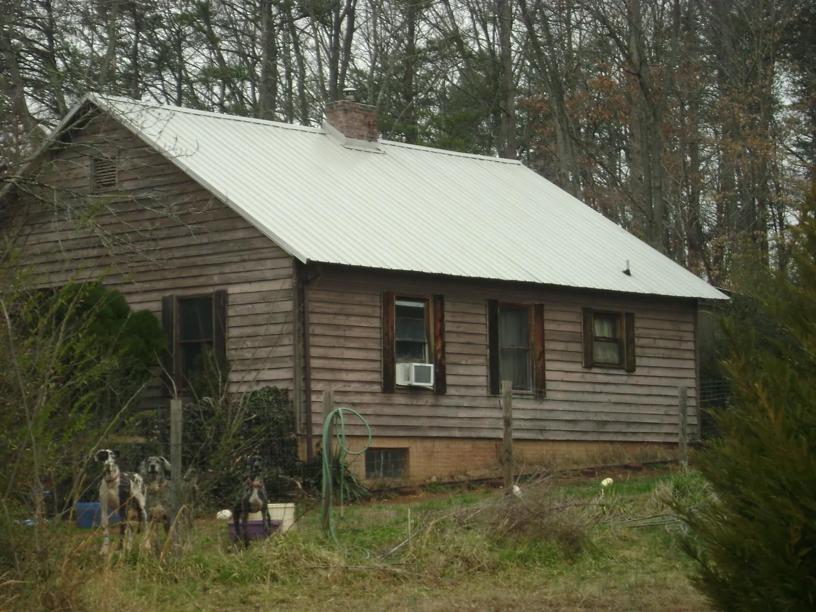 White metal roof on an old wood sided farmhouse, from a Asphalt Shingle Roof Repair job in Warner Robins